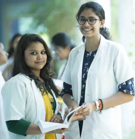 A professional portrait of a senior female medical faculty member wearing a white lab coat and stethoscope, looking directly at the camera with a kind but authoritative expression.